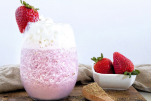 Keto Strawberry Lactation Smoothie in glass with strawberries and whipped cream